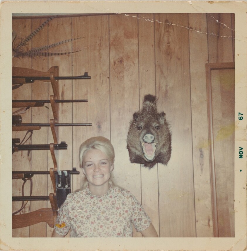 Untitled (Woman posed against wall with guns)