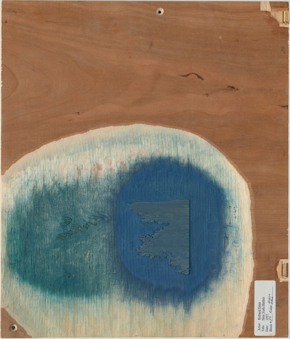 The image shows an oval-shaped area of blue and teal tones on a wooden backdrop with a grainy texture and subtle lines. Within the blue area is an abstract shape resembling a distant land or an island viewed from above, with organic edges resembling a shoreline. The wood's patterns suggest ocean waves, enhancing the geographic or topographical look of the composition.