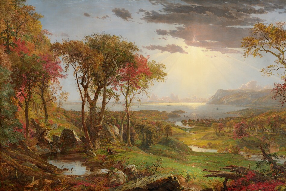 We look out onto a sweeping, panoramic view with trees, their leaves fiery orange and red, framing a view of a distant body of water under a sun-streaked sky in this long, horizontal landscape painting. The horizon comes about halfway up the composition, and is lined with hazy mountains and clouds in the deep distance. Close examination slowly reveals minuscule birds tucked into the crimson-red, golden yellow, and deep, sage-green leaves of the trees to either side of the painting. Closest to us, vine-covered, fallen tree trunks and mossy gray boulders line the bottom edge of the canvas. Beyond a trickling waterfall and small pool near the lower left corner, and tiny within the scale of the landscape, a group of three men and their dogs sit and recline around a blanket and a picnic basket, their rifles leaning against a tree nearby. The land sweeps down to a grassy meadow crossed by a meandering stream that winds into the distance, at the center of the painting. Touches of white and gray represent a flock of grazing sheep in the meadow. A low wooden bridge spans the stream to our right, and a few cows drink from the riverbank. Smoke rises from chimneys in a town lining the riverbank and shoreline beyond, and tiny white sails and steamboats dot the waterway. Light pours onto the scene with rays like a starburst from behind a lavender-gray cloud covering the sun, low in the sky. The artist signed the painting as if he had inscribed the flat top of a rock at the lower center of the landscape with his name, the title of the painting, and date: “Autumn – on the Hudson River, J.F Cropsey, London 1860.”