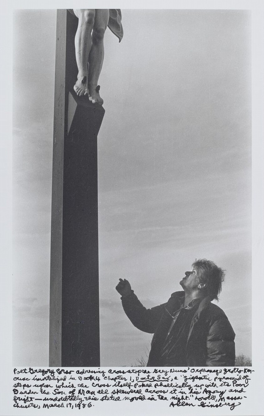 Poet Gregory Corso addressing cross atop the Grey Nuns’ Orphanage grotto Kerouac immortalized in book 4 Chapter 1, _Doctor Sax_, a “gigantic pyramid of steps upon which the Cross itself poked phallically up with its poor burden the Son of Man all skewered across it in his Agony and fright – undoubtedly this statue moved in the night.” Lowell, Massachusetts, March 17, 1986.