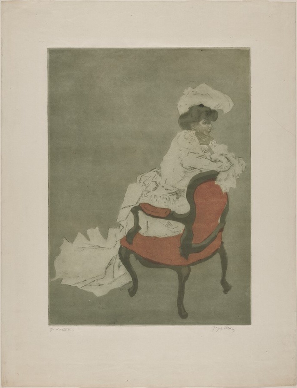 The image shows a partial view of a person's upper body and part of their dress. The person is seated in a wooden chair with reddish upholstery, facing sideways. Their arms rest on the back of the chair, and they appear to be looking to the left. The person has dark hair styled under a large, white hat. Their facial features are subtle, and the clothing is ornate, with loose-fitting, textured fabric. The background is a muted greenish tone, providing a plain backdrop to the figure. No jewelry or additional objects are visible.