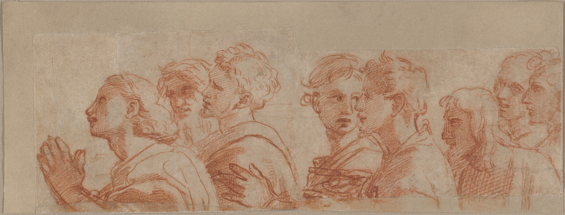 This drawing is a sketch of several people facing the left, depicted from the chest up. The individuals are standing together in a group. Their hair is in a variety of styles, and they are dressed in draped garments. The person at the front of the group has their hands clasped together in front of their chest. The background is plain beige paper, and the lines of the drawing have been done in red.
