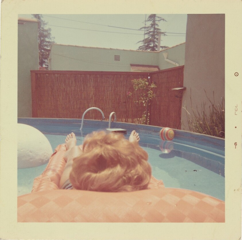 Untitled (Woman floating on raft in pool)