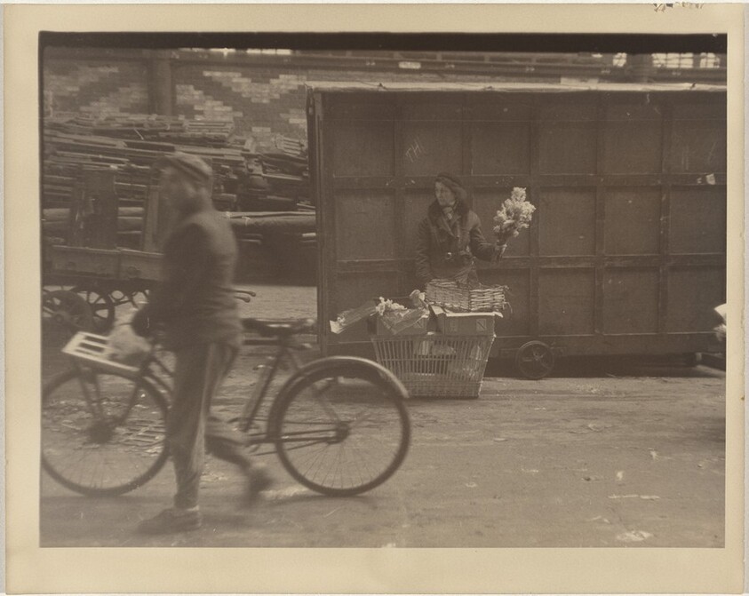 Bicyclist passing flower vendor, Paris