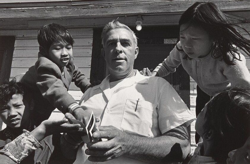 A cook giving Polaroid snapshots to refugee children