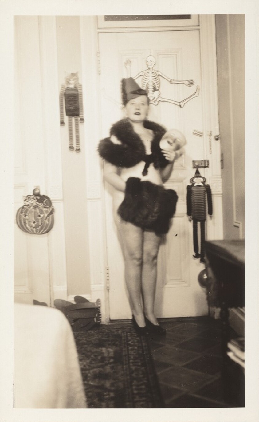 Untitled (Woman posed against door in collar and muff with Halloween decorations)