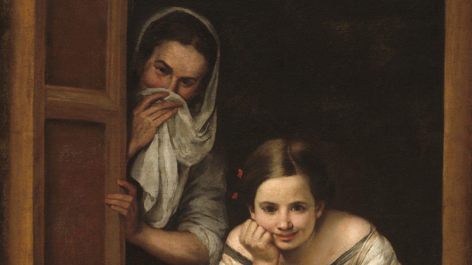 Two women with pale skin look out at us from the other side of a rectangular window opening with a shadowy interior behind them in this vertical painting. On our right, in the lower third of the composition, one young woman leans toward us over her left arm, which rests along the window ledge. She bends her right arm and props her chin on her fist. She looks at us with dark brown eyes under dark brows. She has shiny chestnut-brown hair with a strawberry-red bow on the right side of her head, to our left. She has a straight nose, and her full pink lips curve up in a smile. She wears a gossamer-white dress with a wide neckline trimmed in dark gray, with another red bow on the front of her chest. Her voluminous sleeves are pushed back to her elbows. To our left, a second woman peeks around a partially opened shutter. She is slightly older, and she stands next to the first woman with her body facing us. She tilts her head and also gazes at us with dark eyes under dark brown brows. She has dark brown hair covered by an oyster-white shawl. She holds the shawl up with her right hand to cover the bottom half of her face. Her mouth is hidden but her eyes crinkle as if in a smile. Her left arm bends at the elbow as she grasps the open shutter. She also wears a white shirt pushed back to her elbows, and a rose-pink skirt. The frame of the window runs parallel to the sides and bottom of the canvas. The room behind them is black in shadow.