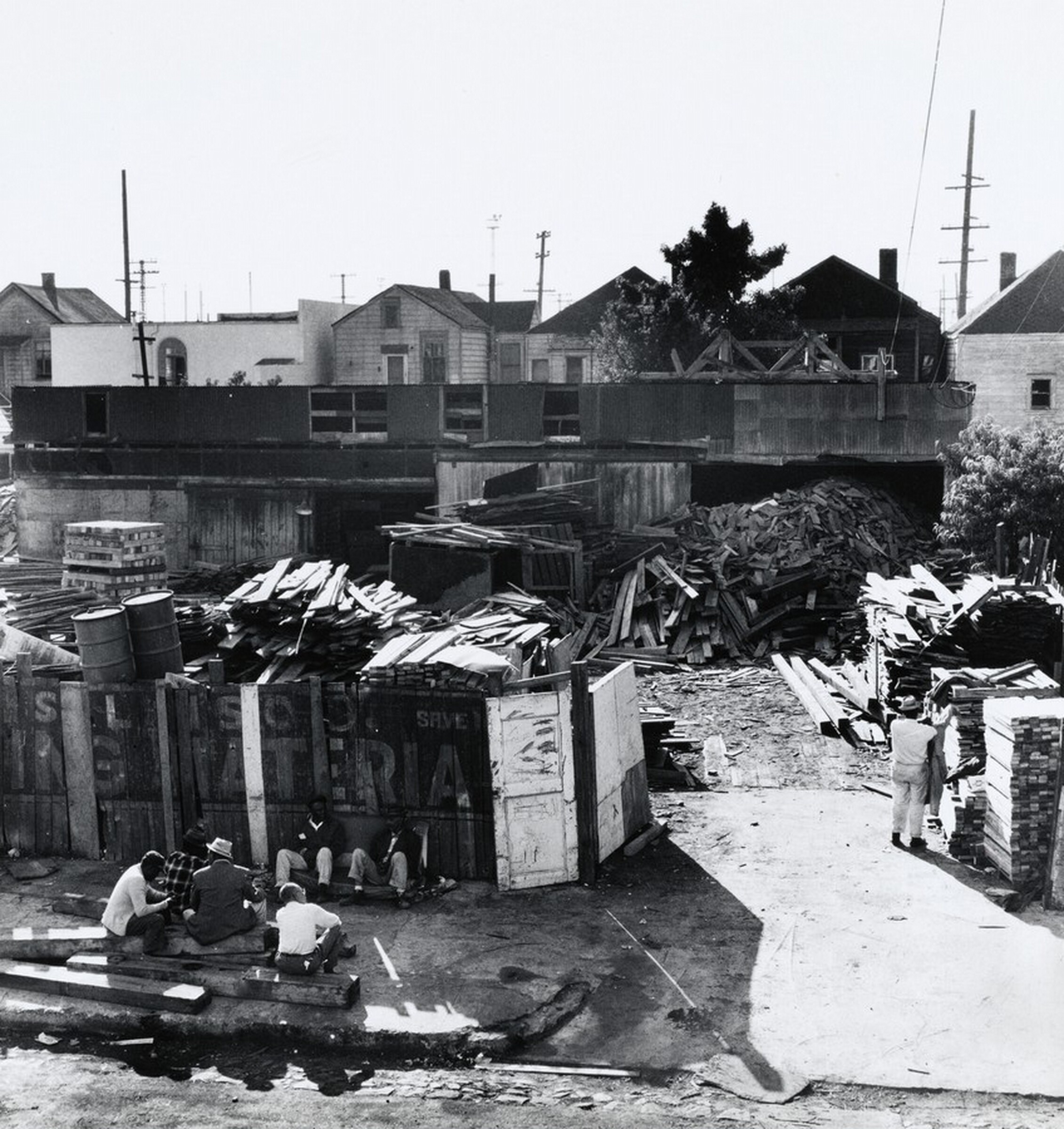 Men Seated Outside Scrap Lumber Yard, West Oakland, California, Joanne Leonard, c. 1963–1971