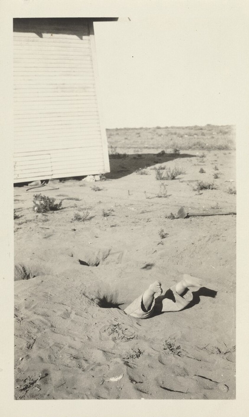 Untitled (Boy's feet sticking out of sand)