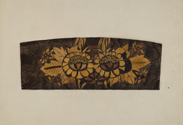 The image shows a rectangular, dark brown object with an intricate floral design in vibrant yellow hues at the center. The color palette is mainly brown and yellow. The floral design covers most of the surface, branching out symmetrically from the center. The background is a plain, light-colored surface.