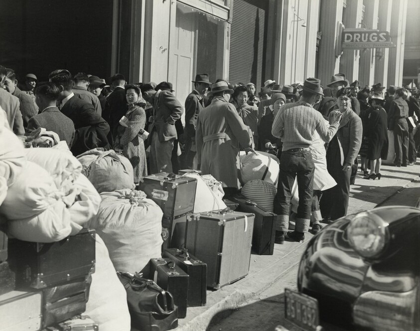 Residents of Japanese ancestry awaiting the bus at the Wartime Civil Control station, San Francisco, California