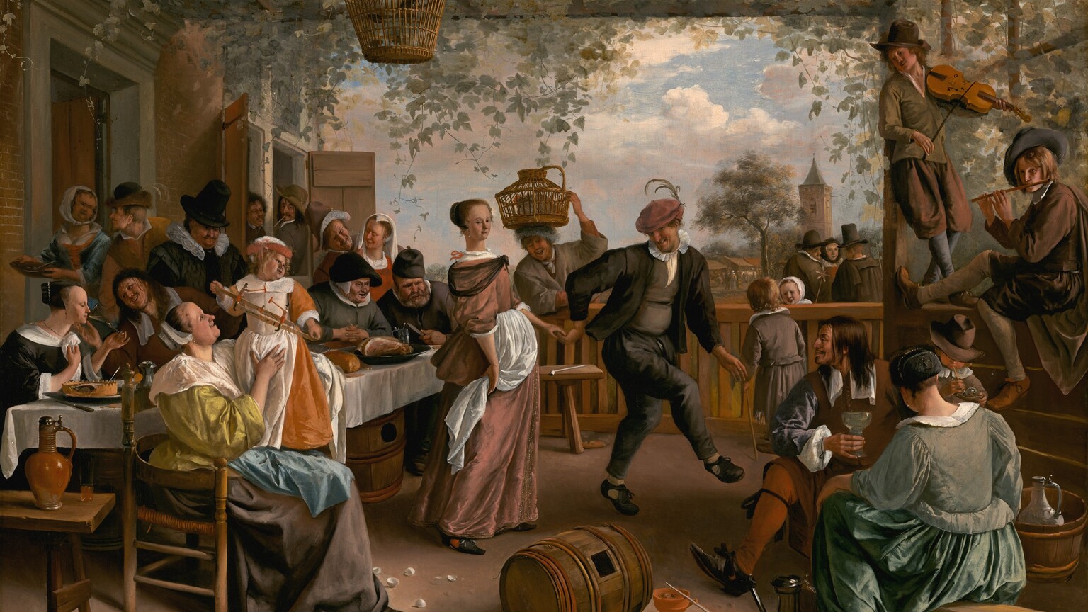 More than a dozen light-skinned men, women, and children eat, drink, talk, and make music around a dancing couple under an arbor in this horizontal painting. Most of the people are dressed in muted tones of green, gray, and black. The patio-like space is enclosed by a railing along the back and a half wall to our right. Sage-green vines and leaves covering the roof-like trellis hang down. Ten men and women sit or stand closely around a long table along the left, next to the exterior wall of a red brick building. A woman sitting in a wooden chair at the end of the table closest to us wears a flax-yellow gown with a wide white collar and a starched white cap. She smiles up at the child she braces in her lap. The child stands and holds a toy in both hands and looks over one shoulder to our right. The child wears a carrot-orange gown with a white pinafore. Two men lean out of open windows at the far end of the brick building, and the people along the table drink, smile, or look on as a man in the center leads a woman by the hand to an open spot under the arbor. He wears a charcoal-gray suit, and a muted pink cap is pulled low over his eyes. He has a long, hooked nose, and light glints off teeth in his smiling mouth. The woman is pulled behind the man, so she stands flat-footed to our left of him. She faces our right but turns to looks at us from the corners of her dark eyes. Her light brown hair is gathered at the back of her head under a pearl-lined covering. She wears a dusty rose-pink gown with a sheer black shawl around her shoulders and white apron at her waist. Beyond the back rail, a man smiles widely as he balances a covered basket containing a gray chicken with one hand on his head. Nearby, a boy on our side of the rail talks with a little girl across the railing, who smiles back. Two men and a woman wearing a black head covering talk a short distance away. Close to us, a man, woman, and child in the lower right corner sit near two young men perched on the half wall, one playing a violin and the other a flute. A gleaming pewter ewer, a wooden barrel with a square opening, a white pipe, a terracotta bowl, broken eggs, a spoon, and an overturned pail of flowers lie scattered across the foreground of the patio. The artist signed and dated the lower left, “JSteen. 1663,” with the J and S overlapping.