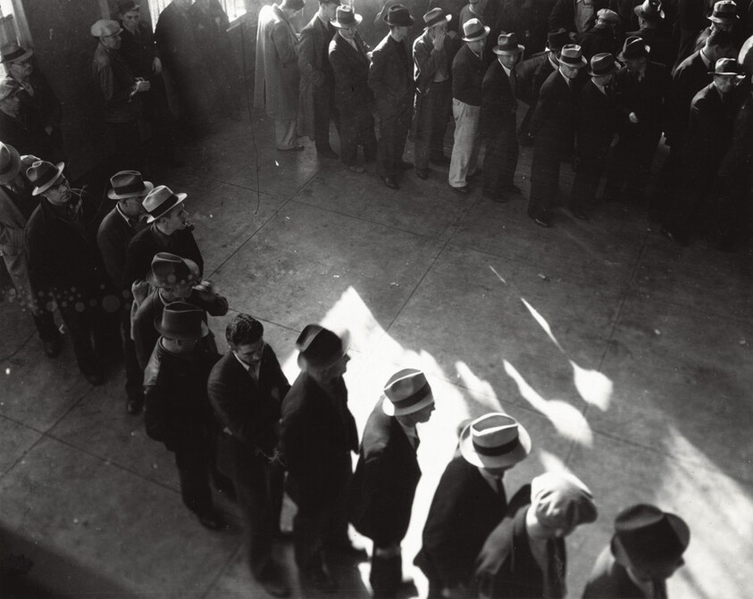 Line of men inside a division office of the State Employment Service office at San Francisco, California, waiting to register for unemployment benefits
