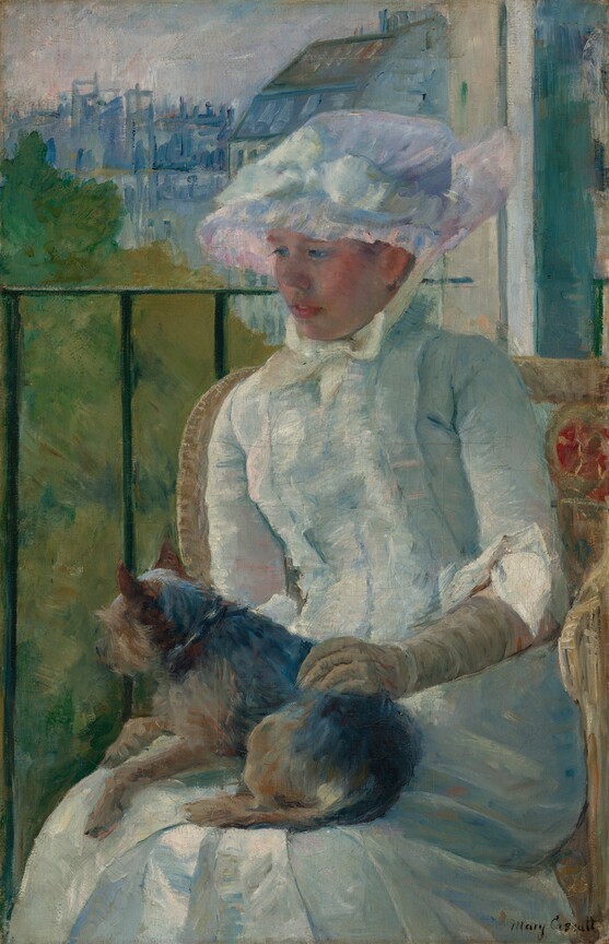 Shown from the knees up, a young woman wearing a white gown and bonnet sits in front of a balcony railing on a sunny day, holding a small dog on her lap in this vertical portrait painting. The scene is painted with visible brushstrokes, which are especially broad in the background and clothing. The woman sits with her body angled to our left, and she looks down in that direction with blue eyes. She has a short, snub nose, rosy cheeks, and her full, pink lips are parted. The woman’s bonnet is tied under her chin with a pale yellow bow. Her dress has a tightly-fitting bodice, elbow-length sleeves, and a long skirt. The bonnet and dress are painted with strokes of faint sky blue, petal pink, lavender purple, and mint green, with cream-white highlights and some darker cobalt-blue and apricot-peach strokes for shading. The dog on her lap lies with its head to our left, lifted as it looks out onto the landscape. The tan glove the woman wears on the arm we can see reaches her elbow, and she rests that hand on the dog’s back. Her right arm, to our left, is hidden below the elbow by the dog. The animal has charcoal-gray fur along its back and tan fur on the legs and shaggy face. The woman sits in a wicker armchair with a crimson-red medallion next to her left shoulder, to our right. The black balcony railing spans the width of the painting at the level of her nose, and has vertical bars. In the landscape beyond, trees to the right are painted loosely with sage green and mustard yellow. Buildings in the distance fill the top quarter of the composition, and are loosely painted with strokes of slate and aquamarine blue. The sky above is streaked with pale blush pink and ice blue. The artist signed the painting in the lower right corner, “Mary Cassatt.”