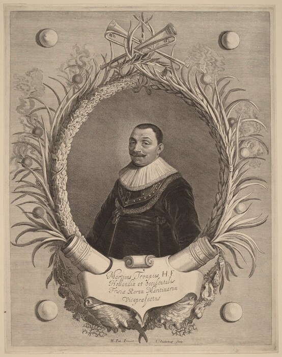 The image is a waist-up portrait of a man in an ornate oval frame. The man is facing slightly to the right, looking at the viewer. He has a moustache and short, dark hair, wearing a dark garment with a large, pleated white ruff collar. The man's attire has an embroidered decorative pattern along the shoulders. The frame has intricate floral and plant-like designs with small spheres emitting smoke and crossed trumpets on top. A banner with text is at the bottom of the frame, and the background is textured with round spheres on either side of the frame.