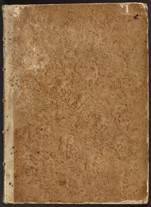 This rectangular, light brown cover is marbled with darker brown, and the edges are worn and chipped. The spine, to our left, is bound by a light tan strip and divided vertically by five projecting ribs spaced along its height. Four small dark brown spots appear on the upper right corner, with a scattering of similar spots over the lower left section.