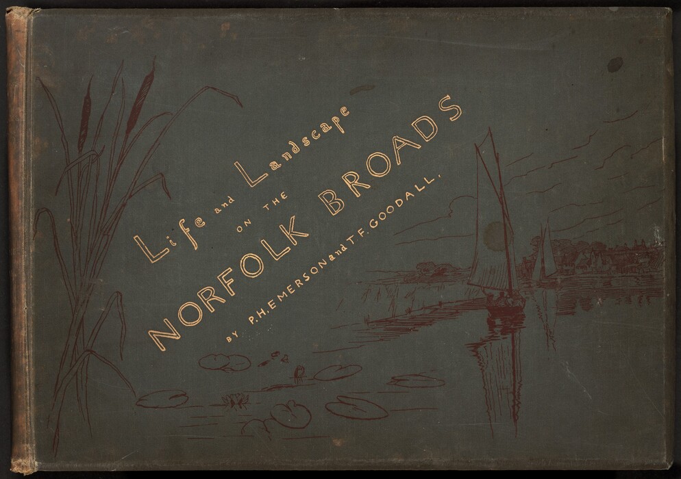 This muted, celestial blue, wide book cover has gold text and a drawn illustration of marshlands and sailboats. The text is oriented at an angle between the lower left and upper right corners. It reads, “Life and Landscape on the NORFOLK BROADS BY P.H. EMERSON and T.F. GOODALL.” In dark brown, cattails rise along the left edge, near the book’s tan-colored spine, and two boats sail away from us toward a harbor town to the right. The spine and cover are worn and scuffed, and there are a few stains.