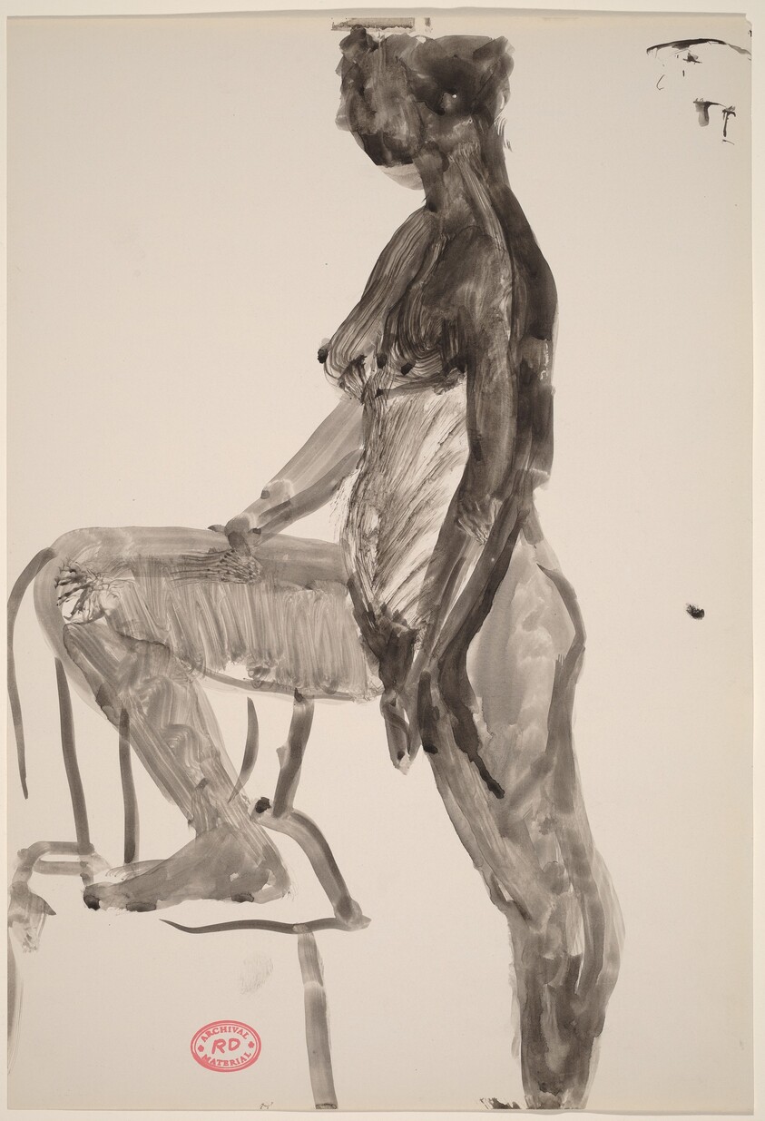 Untitled [standing female nude with right foot in chair: side view]