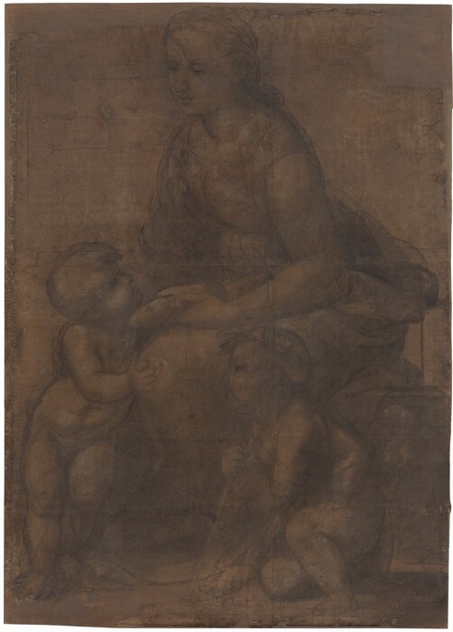 Drawn with gray chalk lines and smudges against dark tan paper, a woman sits facing to our left on a low wall, with two toddler-aged babies at her feet, filling this vertical drawing. Their bodies are outlined with smoke-gray lines and filled in with paler gray areas, giving the drawing an almost ghostly look against the dark paper. Both children have short hair and rounded, pudgy bodies. The woman has a subtly rounded figure, a straight nose, and smooth cheeks; her bow lips are closed. Her wavy hair is loosely pulled back and tied at the nape of her neck. Her dress, with a scooped neckline, is cinched at the waist before flaring into a voluminous skirt. She smiles down at the nude baby who stands to our left, looking up at her and leaning against her knees with his weight mostly on his right foot. Her left hand holds his left arm, which reaches across her lap toward a book she presses against her side with her left forearm. His right hand touches her left knee, nearest us, and her right hand passes behind him to caress his shoulders. The second child kneels in a crouch near the woman’s legs, to our right. Leaning on a slender staff like a walking stick, he wears a garland of leaves in his hair and looks up toward the other boy. Chalk strokes and white highlights around his torso suggest he is wrapped in drapery. Some details are difficult to make out because some of the charcoal-gray lines are loosely sketched and retraced. The corners and edges of the paper are chipped, revealing an underlying surface to which it is attached, and there are crease lines that suggest that the paper was likely folded in the past.