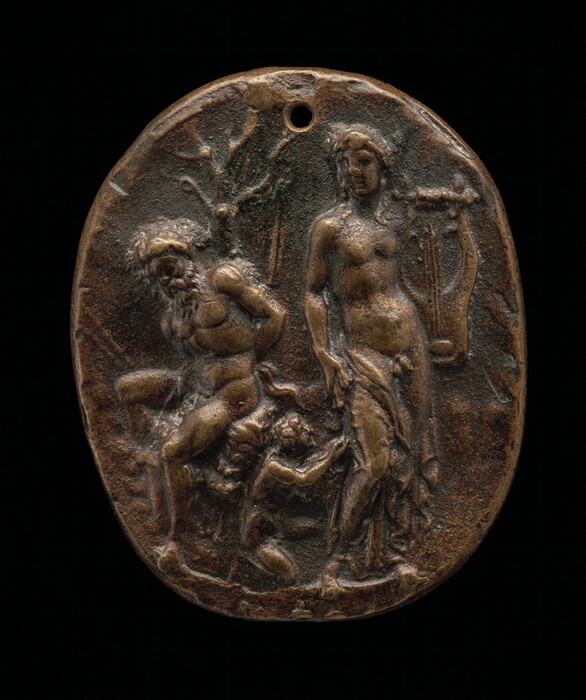 The sculpture depicts two main figures and a smaller figure. On the left, there is a bearded man with a muscular build, hunched over and possibly carrying or being supported by the smaller figure beneath him. His hair and beard appear textured, and he is only partially clothed with a garment over one shoulder. On the right stands a taller, more statuesque figure, likely female, draped partially in cloth, with an upward stance. This figure holds a lyre in her right hand. The smaller figure appears to be reaching up toward the taller figure's draped garment. The sculpture is crafted from a bronze-like material, exhibiting a dark brown color with highlights. The entire piece is oval-shaped with a small hole at the top. The background shows faint trees and foliage.
