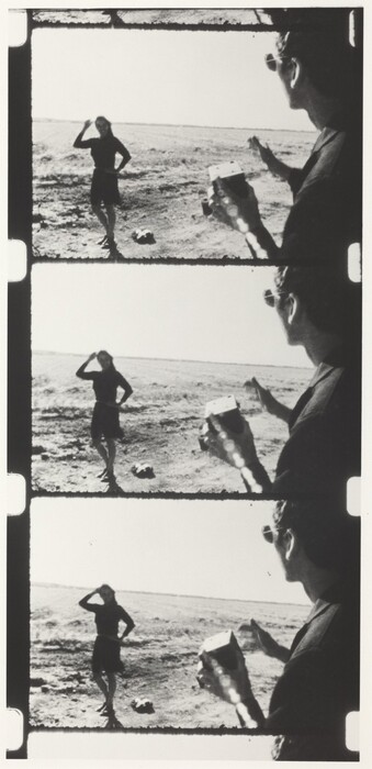 This is a photograph of four black and white film strips showing two figures. The first figure is posing in the distance, and the other figure is closer in the foreground, partially visible from behind. The scene is set in an open barren landscape with a clear sky above. Each frame captures a slightly different moment in time.