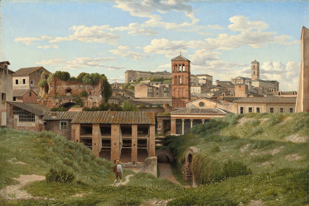 A person, tiny in scale, walks along a path between two grassy mounds that lead back to a band of brown buildings that span the width of this horizontal landscape painting. The grassy mounds are covered with frosty and spring green growth, with a few patches of ivory-white dirt. The person wears a brimmed, straw-yellow hat, a long-sleeved white shirt, knee-length brown pants over white stockings, and a red garment slung over one shoulder. He walks away from us toward a tunnel that runs alongside the right-hand mound, into the heart of the town beyond. The buildings are oatmeal brown, beige, or muted red, and have gray roofs. We can see into a few buildings closest to us. To our left, strokes of parchment brown suggest laundry hung across an open space inside one structure. Plants grow over the wide central arch of a partially ruined building beyond this, also to our left. Other buildings are stacked and staggered along the rolling hills into the distance. In the top third of the painting, thin white clouds float across a pale blue sky.