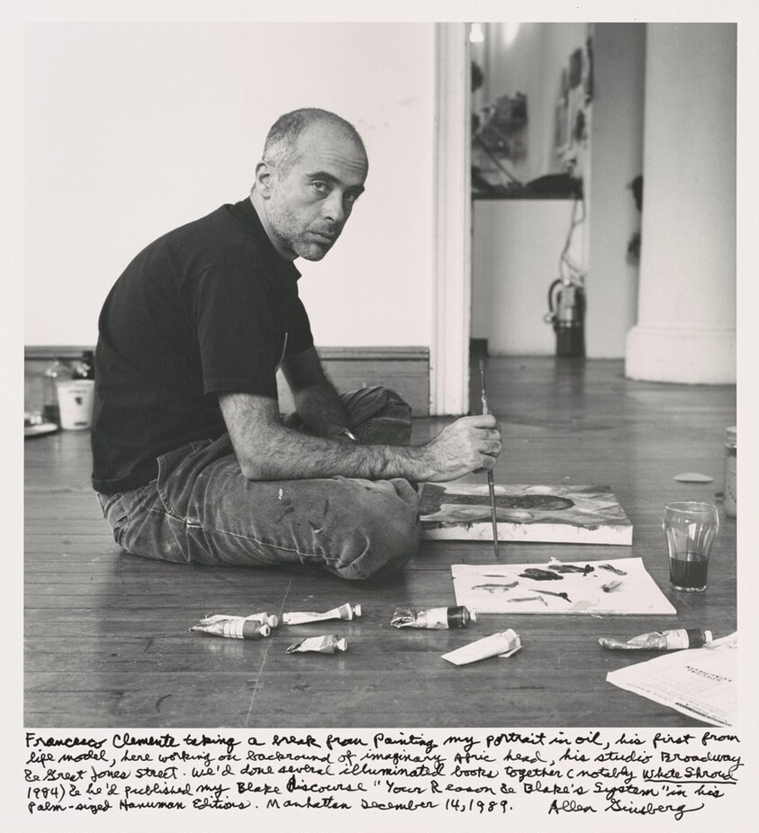 Francesco Clemente taking a break from painting my portrait in oil, his first from life model, here working on background of imaginary Afric head, his studio Broadway & Great Jones Street. We'd done several illuminated books together (notably _White Shroud_ 1984) & he'd published my Blake discourse "Your Reason & Blake's System" in his Palm-sized Hanuman Editions. Manhattan December 14, 1989.
