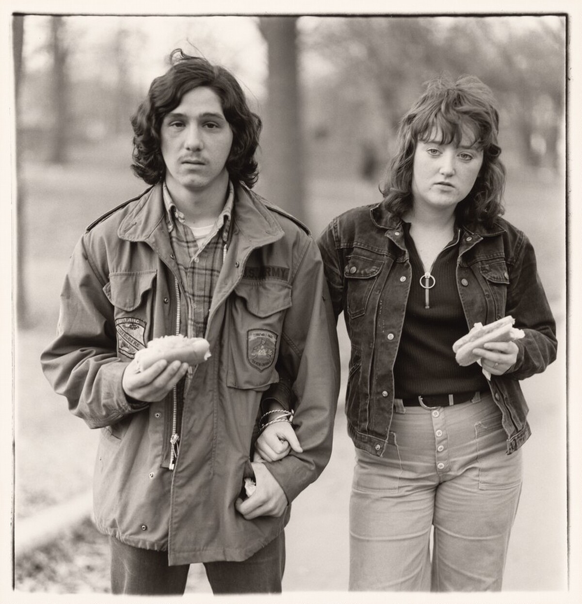 A young man and his girlfriend with hot dogs in the park, N.Y.C. 1971