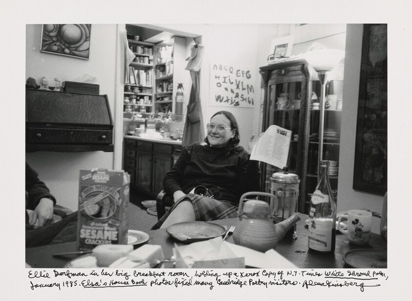 Ellie Dorfman in her big breakfast room, holding up a Xerox copy of N.Y. Times _White Shroud Poem_, January 1985. _Elsa's House Book_ photos fixed many Cambridge Poetry visitors.
