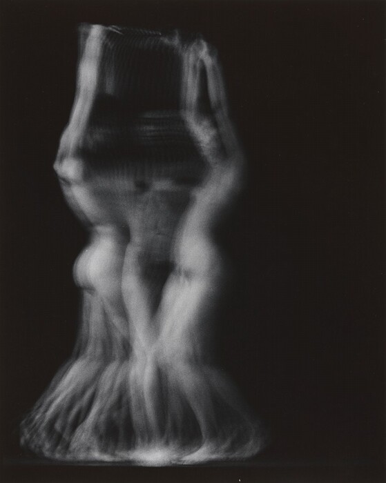 The image displays ghostly, translucent lines and shapes blending into one another. Multiple superimposed outlines of a human figure can be seen within the shapes. The composition conveys fluidity and motion, resembling waves or swirling fabric. The dark background contrasts with the blurred white shapes.