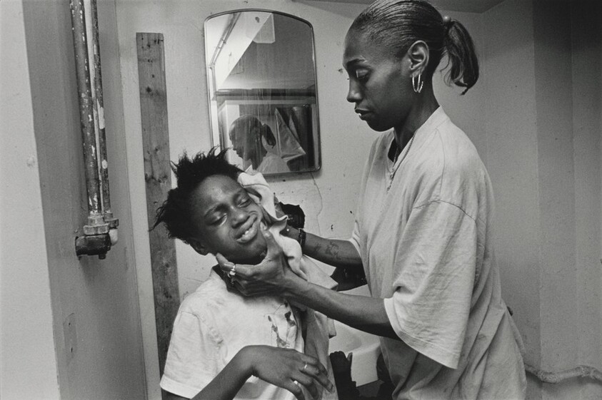 The bathroom at the mission is dreary at best, with holes in the walls and floor, peeling lead paint, no toilet paper, showers without handles. Mothers nevertheless keep their children scrupulously clean, singing praise to God. Here, Renee cleans her daughters face with plenty of elbow grease. Olive Branch Mission, Chicago.
