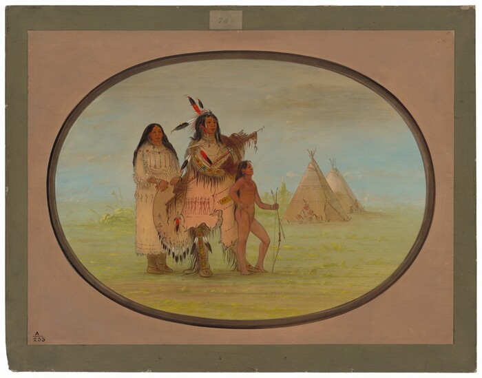 The image shows three individuals in a full-body portrait outdoors. The person in the center stands upright, holding a long, decorated staff. His hair is long, dark, and adorned with colorful feathers and beads. He wears a richly decorated garment with fringes and vibrant patterns, as well as a pair of moccasins. To his right stands a young male child, who is also upright and carries a small bow and arrows. The child's hair is long and unadorned. The child appears to be wearing minimal clothing. To the left of the central figure is a female, wearing a long dress with intricate beadwork and fringe. Her long hair is dark and straight, and she stands with her hands lightly resting by her sides. They are situated on a grassy plain, and in the background, there are two tipis with figures seated near them. The sky is open and light, suggesting a cloudy day.