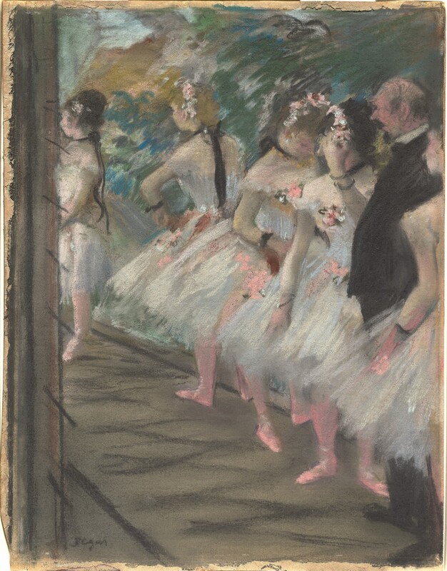 A man wearing a black suit stands in the middle of a line of five ballerinas on a stage in this vertical pastel drawing. The dancer closest to us is cut off by the right edge of the sheet, and the line of dancers angles away from us to our left. The ballerinas’ white costumes have off-the-shoulder bodices and knee-length tutus. Black ribbons encircle their necks and wrists, and their tights and slippers are bright, carnation pink. Pink and white flowers adorn their hair and dresses. The man in black is balding and has a dark goatee. He stands next to the dancer closest to us. Three dancers on his far side seem to stand casually in the wings of the stage, their feet outturned. The final dancer, farther from us, is bright in the stage lights. The floor is ash-gray, and the backdrop is drawn loosely with visible strokes in pine green, ochre yellow, lapis and ice blue. A narrow margin lines the edges of the tan paper. The artist signed the lower left corner, “Degas.”
