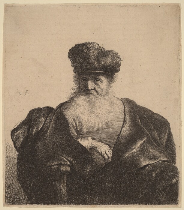 The image depicts an elderly person from the chest up. The individual is seated upright, with one arm resting across their body, and their other hand appears to be gently cradled. Their facial features include deep-set eyes, a prominent nose, and a long, flowing white beard extending downwards. The person wears a large hat covering their head, and their hair is hidden beneath it. Their attire consists of a long, thick, dark garment that drapes heavily over their shoulders. There is no visible jewelry or objects being held by the person. The background is plain and unadorned, with a simple, textured surface.