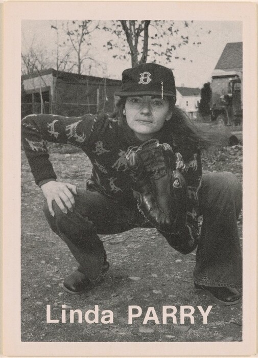 The image depicts a person in a crouching stance, wearing a cap with a letter 'B', long hair, a patterned sweater, and flared jeans. The individual is holding a baseball glove, with a background of trees, buildings, a vehicle, and a rocky surface. The name "Linda Parry" is shown at the bottom of the image.