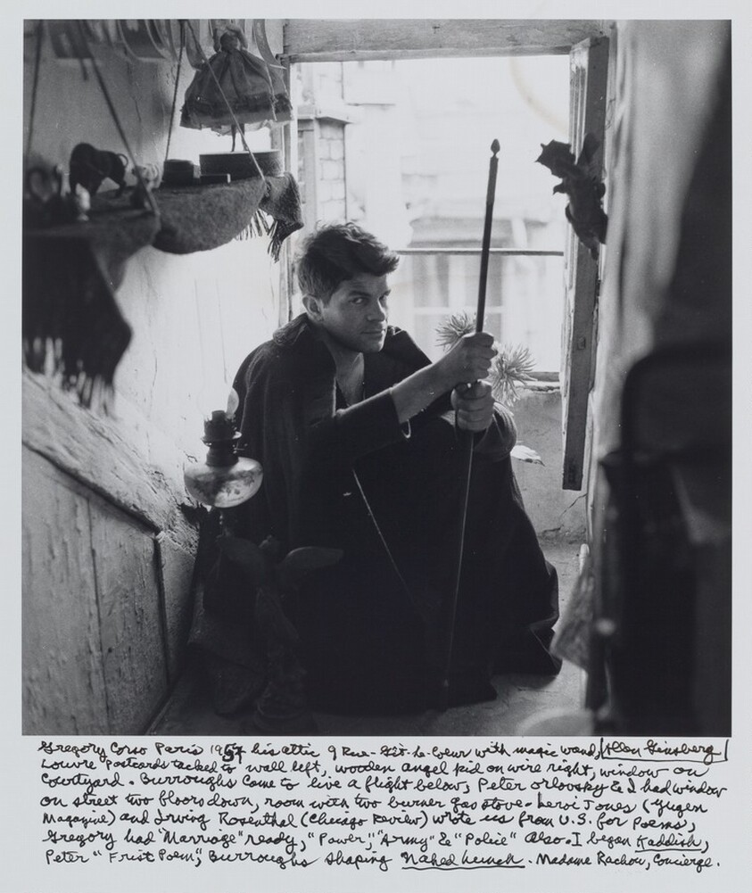 Gregory Corso Paris 1957 his attic 9 Rue-Gît-Le-Coeur with magic wand, Louvre postcards tacked to wall left, wooden angel kid on wire right, window on courtyard. Burroughs came to live a flight below, Peter Orlovsky & I had window on street two floors down, room with two burner gas stove – LeRoi Jones (Yugen magazine) and Irving Rosenthal (Chicago Review) wrote us from U.S. for poems, Gregory had “Marriage” ready, “Power,” “Army” & “Police” also. I began _Kaddish_, Peter “Frist Poem,” Burroughs shaping _Naked Lunch_. Madame Rachou, Concierge.