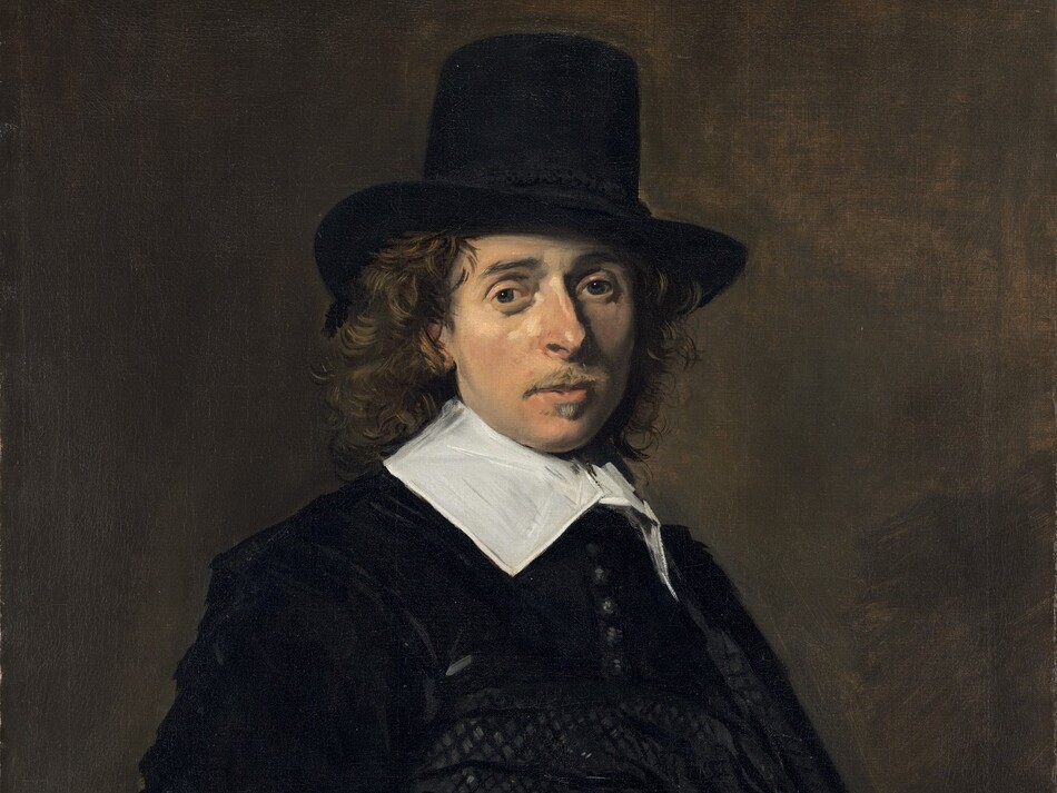 Shown from about the hips up, a man with peachy skin, wearing an ink-black hat and coat with a bright white collar, looks out at us against a dark background in this vertical portrait painting. He stands with his body angled to our right and his face turned to look at us with dark gray eyes. His slim face is framed in long, brown curls under his tall, brimmed hat, which is cocked a little to our right, away from us. He has a straight, prominent nose, lightly flushed cheeks, and a wispy, light brown mustache above a small, pointed goatee under his lower lip. His neck is encased in a broad, starched, white linen collar, its wings lying along his collarbones. His velvety black coat has a row of tightly spaced buttons down the front. A cummerbund or sash wraps around his waist and hips. He rests his right hand, on our left, against his hip near his lower back, palm facing out. He wears a light, dove-gray glove on his opposite hand, and holds a second glove in that hand. The background is earth brown. The portrait is painted loosely, with broader brushstrokes in some areas, such as the hand at his hip and in the folds of the black garments.