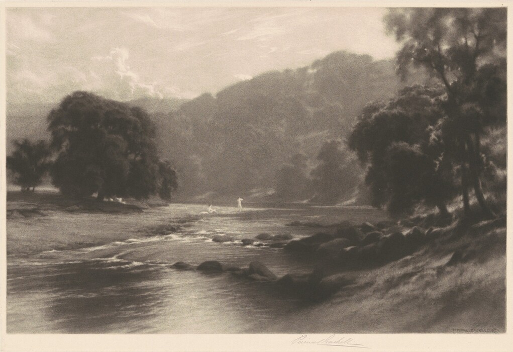 The image is captured from a slightly elevated perspective, showing a landscape sloping down towards a body of water. The horizon meets distant hills, partially concealed by layers of foliage. The style of the print features soft, blurred edges and smooth tonal transitions, akin to charcoal or soft-focused techniques, creating an atmospheric effect. The color palette consists of sepia tones, giving the image a serene quality. In the foreground, there is a stream bordered by rocks and grass, with two figures wading in the distance. Trees with broad canopies line the stream, contributing to the tranquil ambiance.