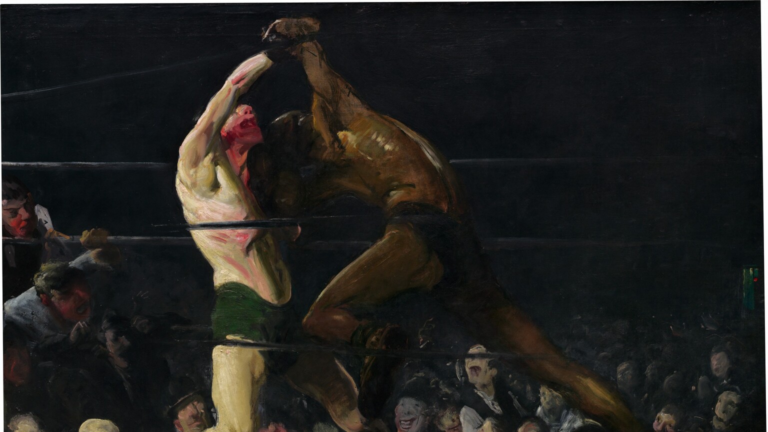 From a darkened arena around a boxing ring, we look up at two bare chested men, one with pale, white skin and the other with brown skin, who lock arms in a boxing match in this horizontal painting. The brushstrokes are loose and visible throughout, making some details difficult to make out. The boxer to our left wears drooping, forest-green trunks and black shoes. He leans back on his bent right leg, closer to us, and tilts his face up. His mouth gapes open and his nose, chin, and neck are smeared with scarlet red, suggesting blood. His pale skin has a green cast, and his chest, arms, and legs are sinewy and muscular. His right arm is raised or pulled up overhead by the boxer to our right. Wearing dark briefs, the second boxer hunches over with head lowered toward the other man’s shoulder. He surges forward onto his deeply bent left knee, closer to us, pushing powerfully off his back leg. His face is lost in shadow and his body has less detail than his opponent, though light glints off his arching back to create gold highlights against his brown skin along his spine, ribs, and muscles of the shoulder. The men’s bodies nearly span the height of the canvas. The black ropes of the boxing ring pass in front of and behind the boxers, and the space around the ring in the top half of the painting is nearly black. Heads and faces of the spectators in the first few rows are lit by the main event and are crowded into the bottom third of the painting. Two spectators on our far left have climbed up and lean on and through the ropes, their mouths open. The crowd, which appears to be all light-skinned men and boys, are painted loosely but their mouths widen in toothy grins or are agape. The artist signed the work in yellow letters against black in the lower right corner: “Geo Bellows.”