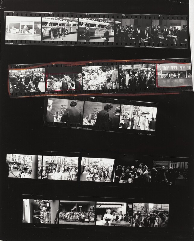 This contact sheet shows five strips of black and white film arranged on a black background. The first of five frames on the top strip shows people on a bus taken from outside the bus. The next two frames show young men wearing uniforms outside a bus, and then two frames of men holding musical instruments. The second strip shows a Black woman looking to our right in front of a group of white police officers; then three frames showing groups of people before another shot of people on the bus. This strip is outlined in red and then the second and fifth frames are also boxed in red. The third strip is made of three frames, two of which show to people at a fruit stand. The third frame is of a man and woman walking toward us on a city street. The fourth strip also has five frames. The first four show crowds of people, but the fourth is noticeably darker. The fifth would be hard to make out if not for the photograph of the police officers above. In the four frames of the final strip are two shots of people gathered around an American flag, a group of children, and a group on a city street.