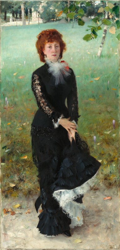 A woman with pale skin and reddish, auburn hair stands facing and looking at us on a grassy lawn, wearing a long black dress in this vertical portrait painting. She stands with her body angled slightly to our right but turns to look at us with heavy-lidded, hazel eyes under pointed brows. She has a narrow face, a straight nose, and her full, pink lips are closed. Her cheeks are lightly flushed and she has a cleft in her chin. Her copper-colored, curly hair is pulled back, and bangs sweep across her forehead. Her black dress has a fitted bodice and the long, narrow skirt ends in layers of ruffles at the hem. A spray of white fabric, perhaps taffeta, is tied in a flaring bow at her neck, partially overlapping a tomato-red object, perhaps a flower or corsage, on her left shoulder, farther from us. The tight sleeves of her dress are black lace, and the cuffs are lined with more sprays of white. She holds up her skirt with both hands, close to her left thigh. Where the hem is lifted, the layers of white fabric underneath are exposed, creating an S-shape that curves down to her feet. The sheen on the layers of ruffles suggest that the black skirt, at least, is made from silk. She wears jeweled rings on the fourth finger of each hand and dangling, sparkling earrings. She stands on an oyster-colored ground, probably a walking path, in front of a lawn that fills most of the background. Touches of yellow and pale purple suggest flowers in the lawn, which fades from muted, pine green close to us to mint green in the distance. The carpet of the lawn is broken only by a birch tree near the upper right corner. A spray of leaves, presumably from a tree just outside the composition, dips into the scene at the upper right as well. Some trees and a white, stone structure with steps and a balustrade line the top edge of the composition. The artist inscribed the work with brown script in the lower right corner, where it reads: “John S. Sargent Ronjoux 1879.”