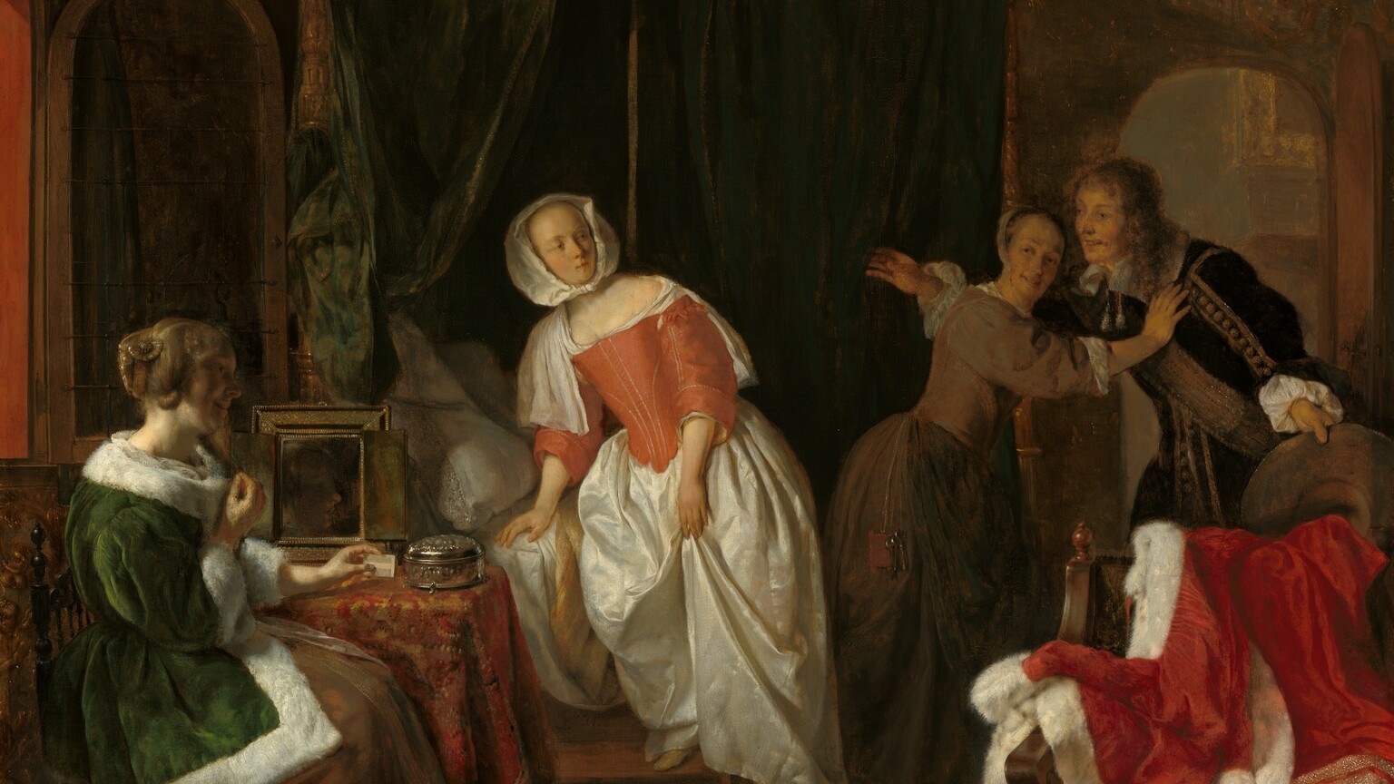 A young, smiling man bursts through the door of a dimly lit bedroom occupied by three women in this vertical painting. All four people have pale skin. The arched door is to our right and the man faces our left with his arms spread wide. He leans slightly forward as he holds the wide brim of his hat out by his left side, to our right. Shoulder-length chestnut-brown hair frames his face, and he wears a velvety brown jacket trimmed with tan stripes and pompoms down the front and along the sleeve we can see. A broad sash crosses his chest and tassels hang from his wide, white collar. Between us and him, a wooden chair is draped with a crimson-red cloak trimmed with white fur and bands of gold. A pewter pitcher and candlestick rest on the pine floor in front of it, near the lower right corner of the painting. The man is stopped at the door by a woman wearing a sable-brown gown with a tight-fitting bodice and a white cap on the back of her head. Her body faces the man as she leans toward him with her outstretched right hand resting on his shoulder, and she turns her smiling face back over her shoulder. Light from an open window on the left illuminates the woman in the center, who steps down from a bed enclosed by forest-green, velvet curtains trimmed with gold fringe and tassels. The curtains are parted behind her to reveal white pillows. She wears a long, gleaming white satin skirt topped by a tight-fitting coral-red bodice stitched with thin lines of gold. A white neckerchief covers her shoulders and is partially tucked into the bodice. Her head is covered by a white kerchief knotted under her chin. Her body faces us with one foot on a step stool, and the other foot reaches down to a gold and red shoe on the floor. Its mate lies nearby, pointing away from us. Her head is turned to our right to look at the man. She has a thin face with a high forehead, and small mouth is closed or pursed. Closest to us and near the lower left corner of the painting, the third woman sits alongside a small table under the open window. She wears a long, pine-green jacket trimmed with white fur over a brown skirt. Her auburn hair is partially coiled around her head, while some locks fall in bunched curls. She sits facing our right in profile with her back to the window, so her smiling face is mostly in shadow. Her left arm rests on the table, which is draped with a red and copper patterned cloth, and she holds a white comb in that hand. A mirror and round silver box sit on the table next to her. A small brown and white dog stands by her feet, its head tilted up to look at the others. The far wall of the room is covered with a faint pattern of golden brown vines and leaves against a forest-green background. The artist signed the painting on the face of the step leading up to the bed, “G. Metsu.”
