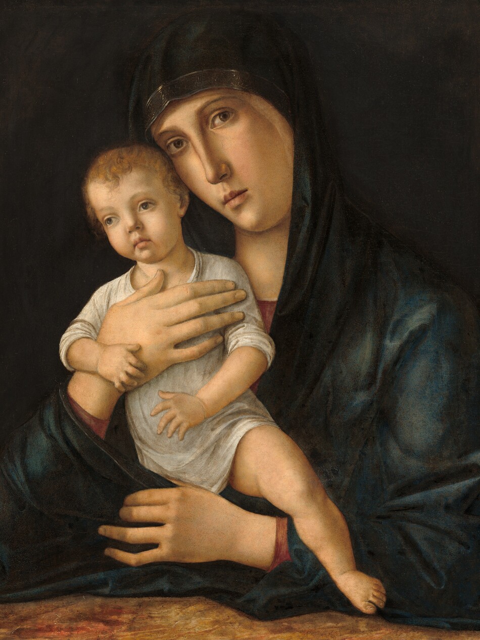 Shown from the waist up, a young woman holds a baby up against her chest in this vertical painting. They both face us and have pale skin. The woman holds the baby against the right side of her chest, to our left, and she tips her slender, oval face toward him. She looks out at us with hazel eyes under thin, arched brows. She has a long nose, smooth cheeks, and a pale pink, bow mouth. The neckline and the cuffs of her garnet-red gown peek out from beneath a dark, spruce-blue, gold-edged mantle that covers her head and wraps around her body. One forearm rests along a surface marbled in red, brown, and tan. With her other hand, she supports the chest of the baby, who wears a long, white robe. The sleeves and hemline are pushed up to reveal his pudgy arms and the leg we can see. The infant has wavy, reddish-brown hair, delicate features, and large, green eyes under faint brows. His head also tilts to our left, and he gazes off in that direction. His exposed left leg, on our right, dangles over the woman’s arm, his toe nearly brushing the tabletop. His other leg is tucked within the folds of her robe. The long fingers of her free hand curl around the child’s hidden leg. The pair are warmly lit from the upper left and set against a dark, earth-brown background.