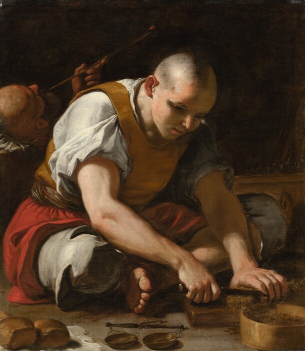 A light-skinned, clean-shaven man sitting cross-legged on the floor nearly fills this almost square painting. His body is angled to our right, and he bends forward, using a knife to cut a block of dried tobacco leaves on a wood board. A straight-edged bowl is nearby to collect the flakes. The man’s head is unevenly shaved so is short on the side and bushier down the middle of his head to the back. He has a round nose, and his pink lips are parted. He wears a golden-yellow vest over a white shirt, the puffy sleeves roll up to expose the upper arms. A scarlet-red overskirt drapes across his hips over roomy slate-gray, knee-length pants. He is barefoot, and we see the underside of the toes closer to us. A scale and two roll-sized loaves of bread on a white cloth sit on the ground in front of him along the bottom edge of this canvas. Light falls across the scene from our left so the far side of his face is in shadow, as is the space behind the man. Only the top of the head of a second man, also bald, and a hand holding a long, glowing tobacco pipe are clearly visible in the shadows. The man lies with his head toward us, and his body disappears behind the other person.
