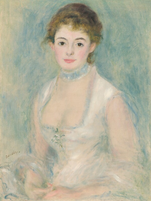 Shown from the hips up, a pale-skinned young woman wearing a white dress sits smiling gently at us in this vertical portrait painting. Blended strokes of pearl white, cool green, and muted blue create an overall soft, almost blurred look. The woman’s body is angled to our left, but she turns her face to look at us with brown eyes under dark, curved brows. She has a heart-shaped face with rosy cheeks, a thin, short nose, and full, pink lips, which are closed in a smile. Her honey-blond hair is swept up and back, but a few tendrils curl on her forehead and the nape of her neck. The neckline of her sleeveless white dress is cut low. The bodice fits tightly to a narrow waist, and a sprig of flowers is suggested by a few strokes of fern green and bright white at the center of the chest. A pale blue collar or ruffled band encircles her neck like a choker. Her hands rest together in her lap, and a white cloth loops over her forearms. The background is painted with loose strokes of powder blue and sage green against the off-white of the canvas, which is visible in some areas, especially along the left edge. The artist signed the painting near the woman’s elbow to our left, “Renoir.”