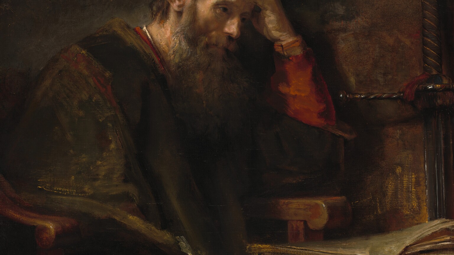 Shown from about the knees up, an older, bearded, pale-skinned man sits at a desk with his head in one hand in a shadowy room in this vertical painting. His body is angled to our right, and he sits in a heavy wooden armchair next to a desk. His left elbow, farther from us, rests on the chair’s arm, and he holds that hand to his forehead. He holds a quill with his other hand, which brushes his knee. He has ash-brown hair covered at the back by a cap and a long shaggy beard. He looks off to our right with dark, shaded eyes. His voluminous brown robe is brushed loosely with golden brown highlights. The rust-red garment under the robe is visible at the sleeves, neckline, and one knee. The desk, to our right, has a stack of papers or parchment. The oversized hilt of a long sword leans against the wall behind the desk. The background is painted with areas of earth and chestnut brown. Some areas of the scene are loosely painted so brushstrokes are visible, especially the brightest white highlights on his collar, the quill, the edges of the parchment, and glints on the sword. The artist signed the painting on the face of the desktop, near the lower right corner: “Rembrandt f.”