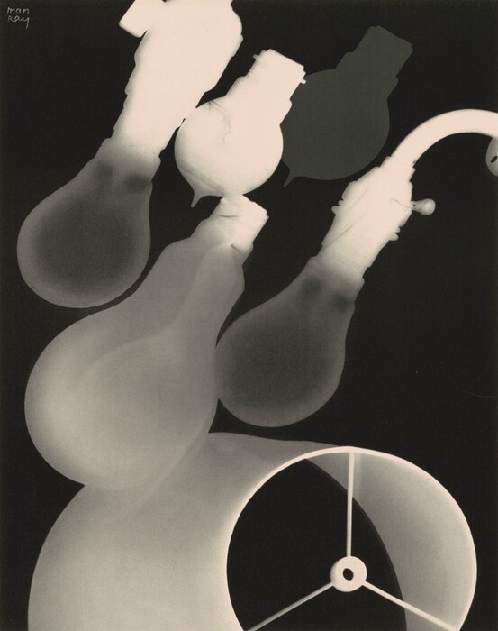 The image shows an assortment of overlapping shapes resembling bulbs and curved lines on a dark background. Some forms resemble elongated lightbulbs with distinct ridges and bases, curving across the visual plane. A circular shape at the lower part resembles the end of a funnel or a megaphone with radiating spokes from its center. The arrangement of shapes and lines suggests a collection of everyday electrical components abstracted into an artistic form.
