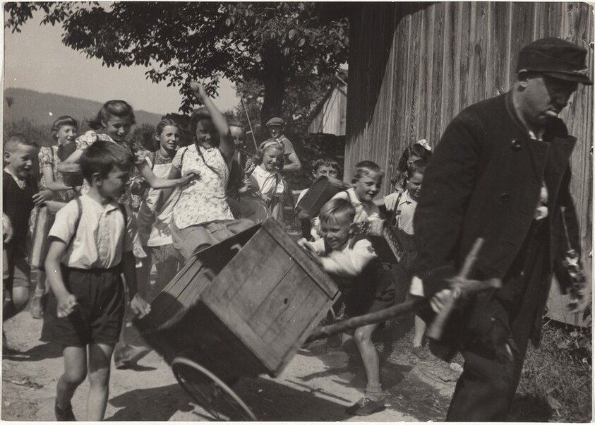 Actor with wheelbarrow followed by children--Filming "Steibruch"