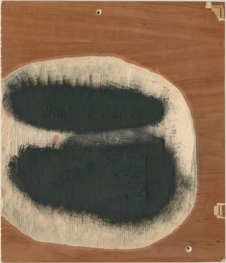 The image features two elongated, dark ovals that hover horizontally within a rough circular boundary in the center of the composition, set against a wooden texture background. The textured lines and shadows surrounding the ovals add a sense of depth, while the wood grain of the background introduces a natural, earthy element to the image.