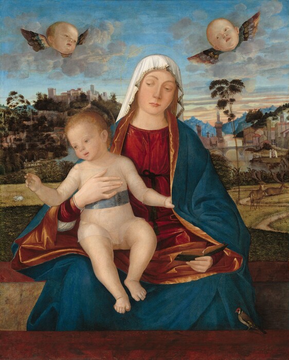 Shown from the shins up, a woman holds a seated child in her lap below two winged baby heads and in front of a deep landscape in this vertical painting. The woman, child, and faces above all have pale skin and blond hair. The woman sits at the center of the painting with her body facing us. Her head tips slightly to our right, and she looks down and to the left with heavy-lidded eyes. She has a heart-shaped face, and her pink lips are closed. A white cloth drapes over her head and back beyond her shoulders. Her ruby-red dress is tied with a dark green, nearly black cord around the waist, and a voluminous lapis-blue robe with a coppery gold lining drapes heavily over her shoulders and covers her lap. She holds a book with a dark green cover open in her left hand, to our right, and braces the baby’s chest with her other hand. Both she and the child have delicate, gold lines creating halos. The baby’s pudgy body also faces us, and he wears only a translucent white garment that comes down to his elbows and hips. A slate-blue band is around his middle. The child looks down and to the left with light hazel eyes. He and the baby heads above have round faces, snub noses, rosy cheeks, and parted pink lips. He lightly grips the edge of the woman’s robe with his left hand, to our right, and holds the other hand up with first two fingers and thumb raised. The pair sit on a wide, maroon-red ledge or bench behind a second ledge, which runs across the bottom edge of the painting. A small bird with a tawny brown body, yellow-tipped wings, and a red, black, and white head perches on the right side of the closer ledge, near the lower right corner. A dirt path winds across a grassy area beyond the ledges. A white rabbit crouches in the distance to our left and two four-legged animals, perhaps stags, are to the right. Towns on hills along a body of water reach into the deep distance, where ice-blue mountains line the horizon about two-thirds of the way up the composition. Streaks of pale pink and yellow over the mountains deepen to blue across the top of the painting. The two baby heads are each flanked by a pair of brown and gray wings, and they float in banks of pale gray clouds.